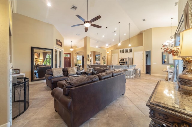 living room featuring ceiling fan with notable chandelier, high vaulted ceiling, and light tile patterned floors