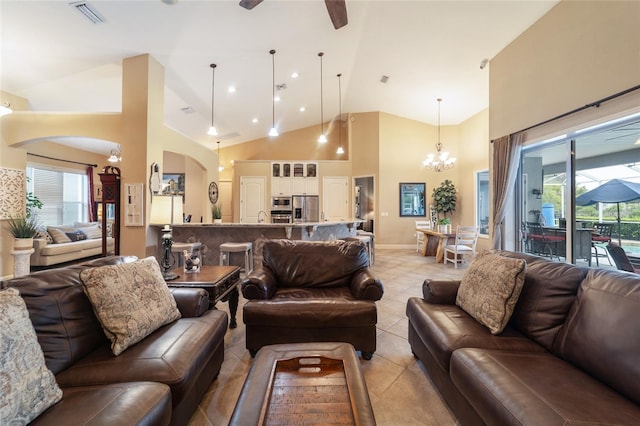 living room with light tile patterned floors, sink, ceiling fan with notable chandelier, and high vaulted ceiling