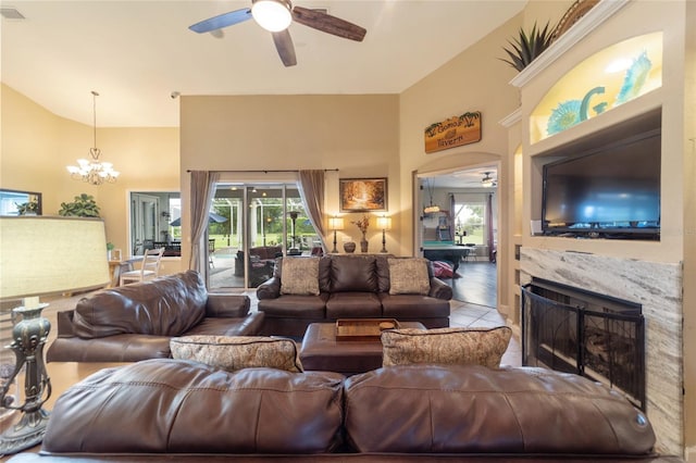 living room featuring a fireplace, pool table, ceiling fan with notable chandelier, and tile patterned flooring