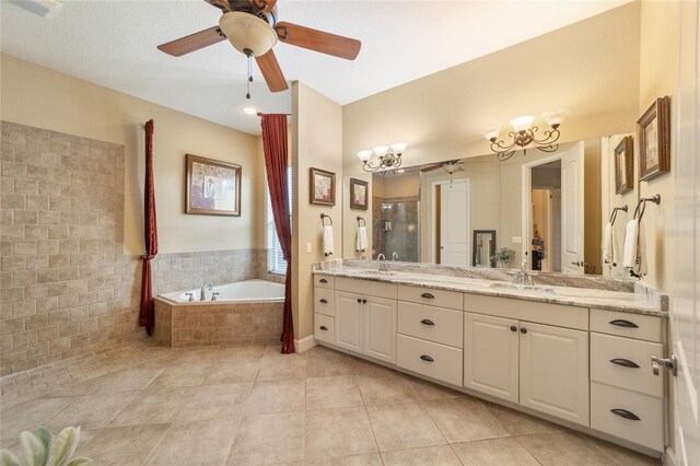 bathroom with ceiling fan with notable chandelier, vanity, tile patterned floors, and shower with separate bathtub