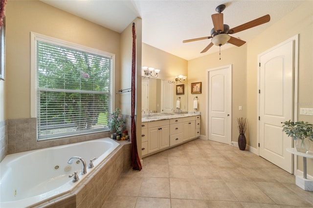 bathroom with ceiling fan with notable chandelier, tiled tub, vanity, and tile patterned flooring