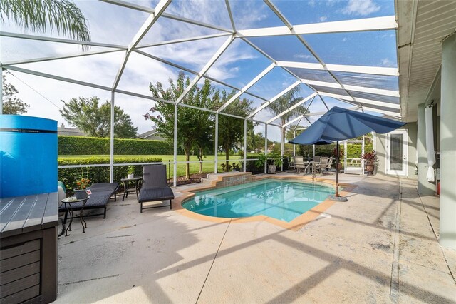 view of swimming pool with glass enclosure and a patio area