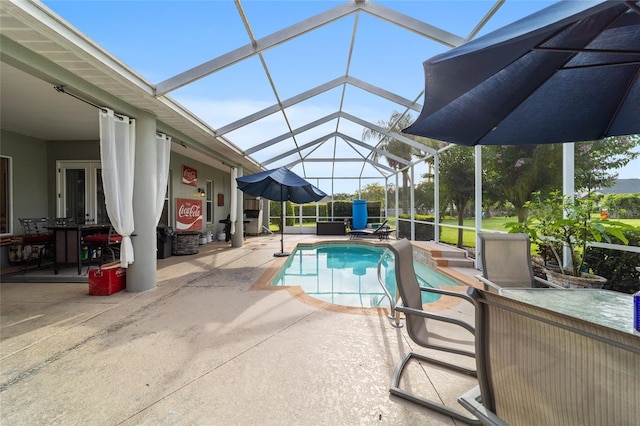 view of swimming pool with glass enclosure and a patio