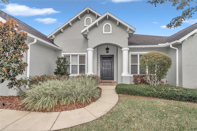 doorway to property with a lawn