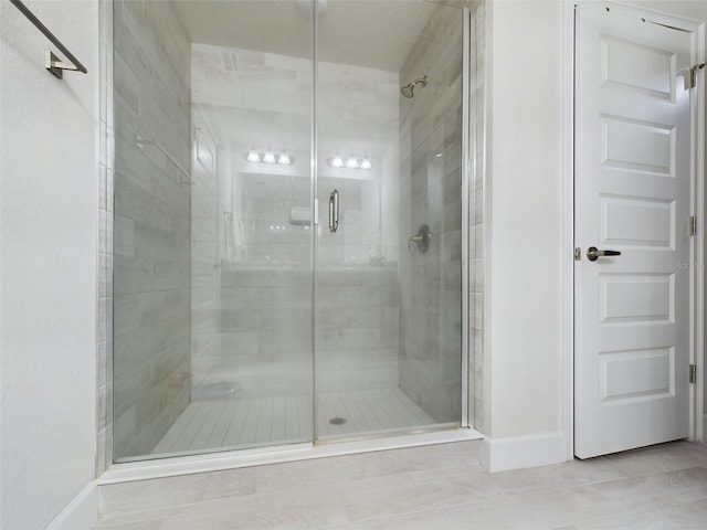 bathroom with tile patterned flooring and walk in shower