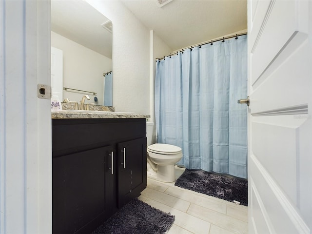 bathroom featuring tile patterned flooring, vanity, and toilet