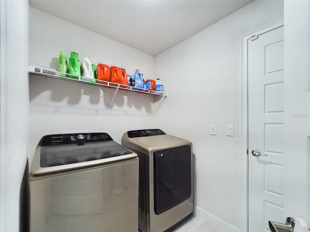 clothes washing area with washing machine and dryer