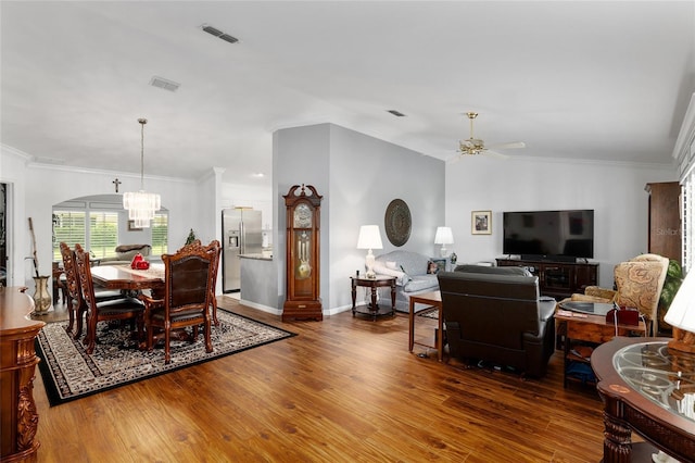 dining area featuring ceiling fan with notable chandelier, dark hardwood / wood-style flooring, and ornamental molding