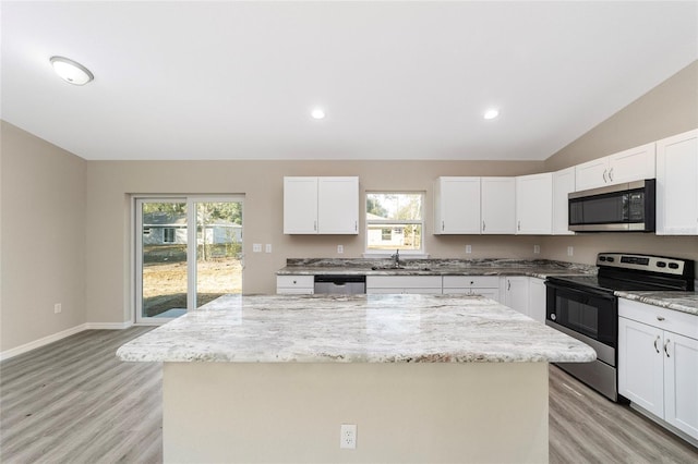 kitchen with white cabinetry, stainless steel appliances, and a kitchen island