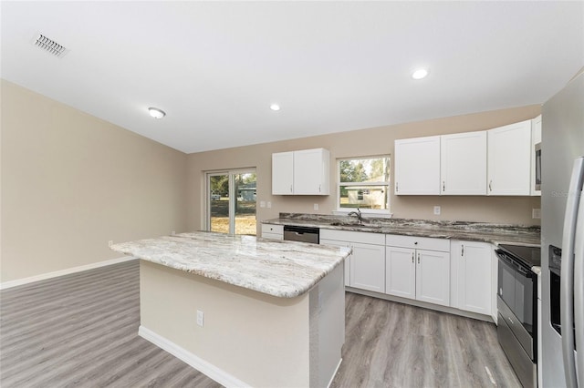 kitchen featuring appliances with stainless steel finishes, white cabinetry, and a center island