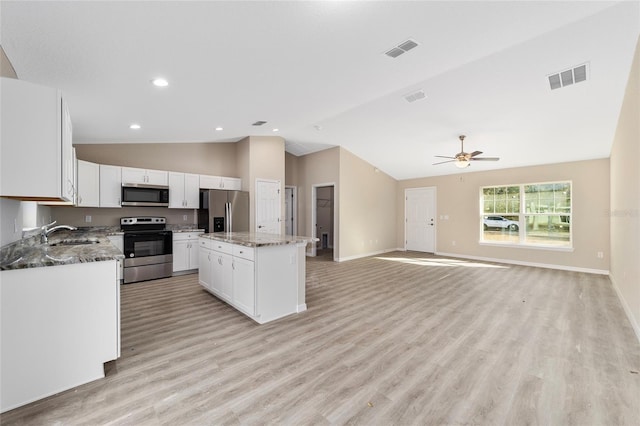 kitchen featuring a kitchen island, white cabinetry, stainless steel appliances, light hardwood / wood-style floors, and ceiling fan