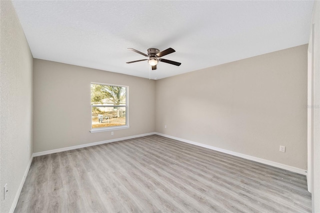 spare room with light wood-type flooring, ceiling fan, and a textured ceiling