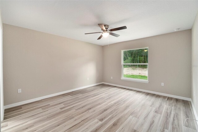 spare room with ceiling fan and light wood-type flooring