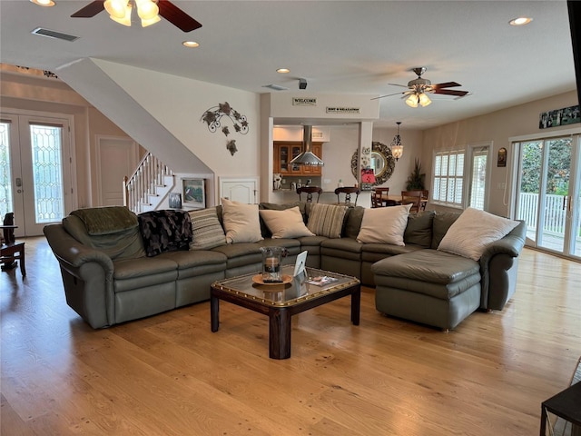 living room with plenty of natural light, light hardwood / wood-style floors, and ceiling fan