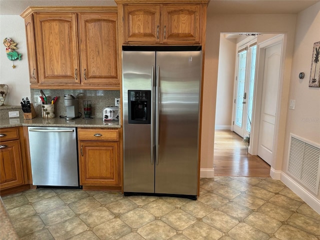 kitchen featuring light stone countertops, appliances with stainless steel finishes, and backsplash