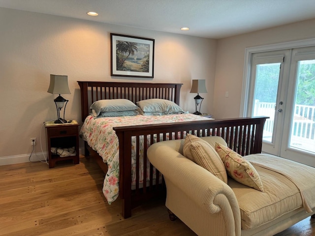 bedroom with hardwood / wood-style floors and access to outside