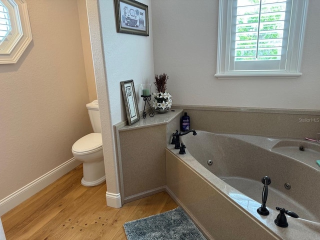 bathroom featuring hardwood / wood-style floors, toilet, and a bathing tub