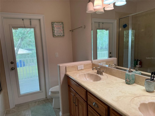 bathroom featuring vanity, an inviting chandelier, toilet, and a shower with shower door