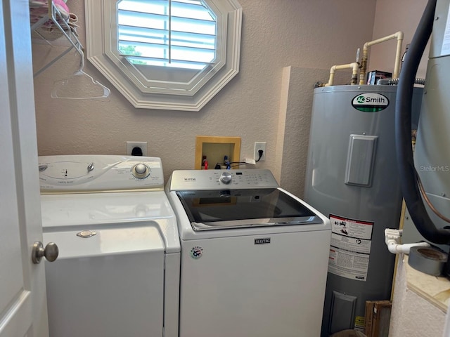 washroom featuring electric water heater and independent washer and dryer