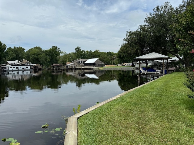 view of dock featuring a water view and a yard