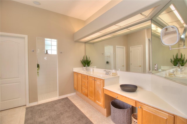 bathroom with tile patterned flooring, vanity, and a tile shower