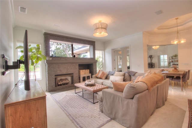 living room featuring crown molding and a stone fireplace