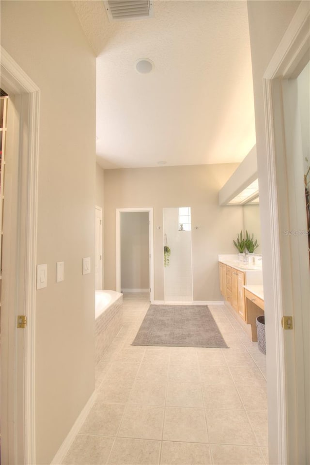 bathroom with vanity, a washtub, and tile patterned floors