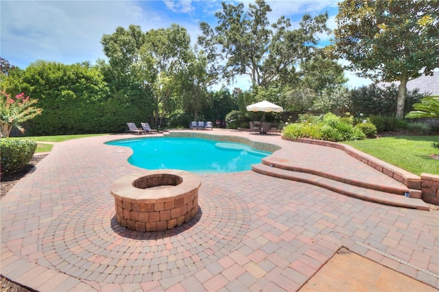 view of swimming pool with a patio and a fire pit