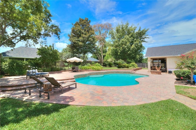 view of pool with a patio and a lawn