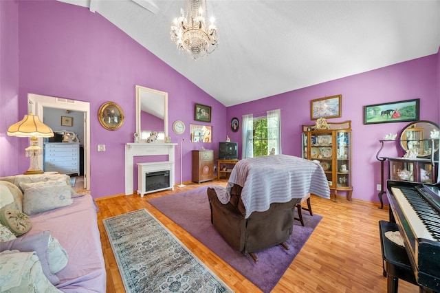 living room with light wood-type flooring, a textured ceiling, high vaulted ceiling, and a notable chandelier