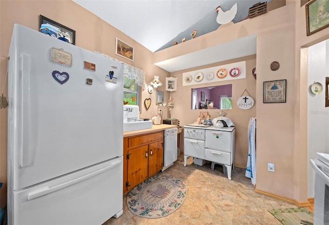 kitchen featuring white appliances and vaulted ceiling