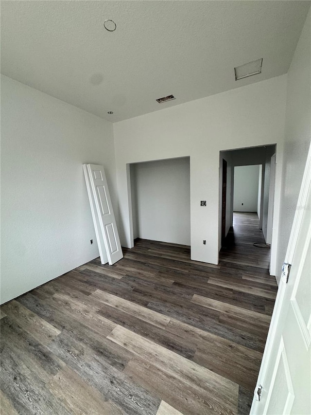 unfurnished bedroom featuring dark wood-type flooring and a textured ceiling