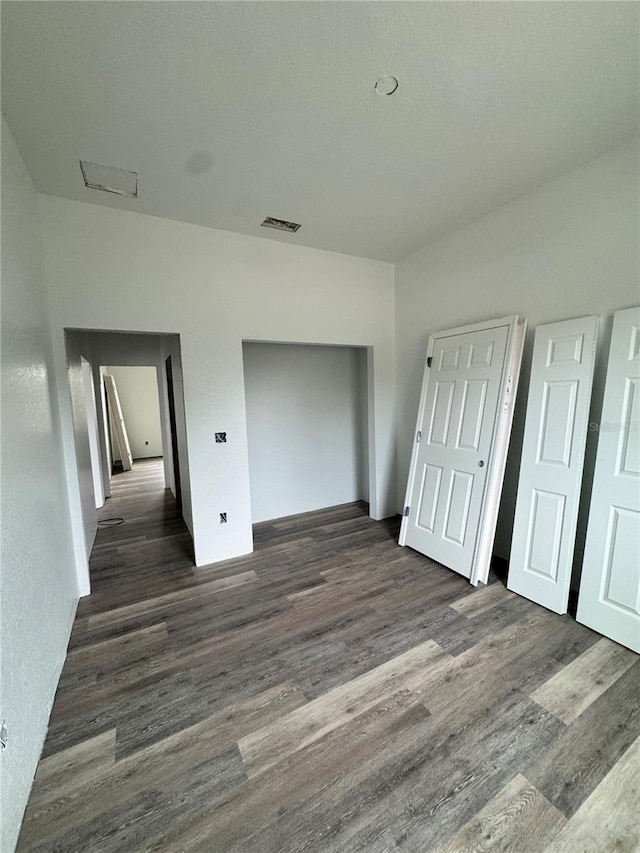 unfurnished bedroom with dark wood-type flooring