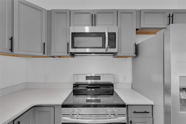 kitchen featuring stainless steel appliances and gray cabinetry