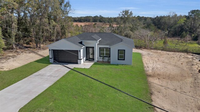 view of front of house featuring a garage and a front lawn