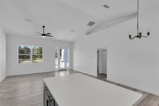 interior space with hardwood / wood-style floors, high vaulted ceiling, and ceiling fan with notable chandelier