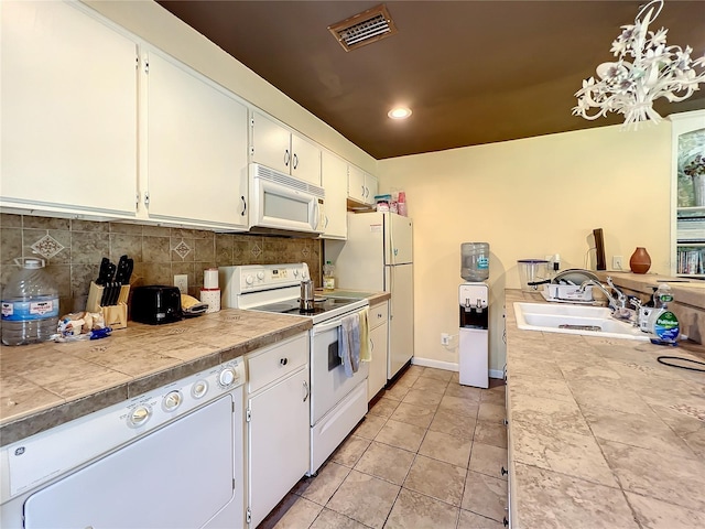 kitchen featuring sink, white cabinetry, tile counters, white appliances, and backsplash