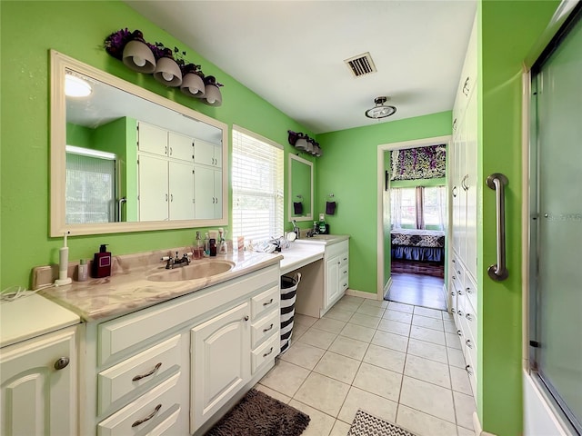 bathroom with tile patterned floors, shower / bath combination with glass door, and vanity