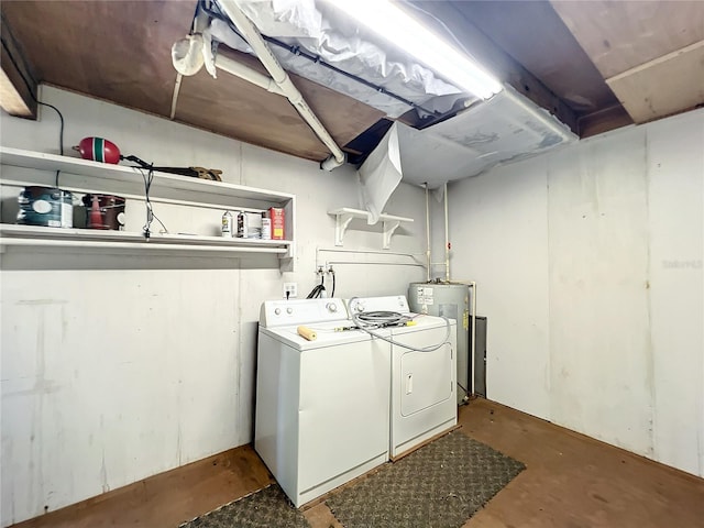 clothes washing area featuring electric water heater and washer and clothes dryer