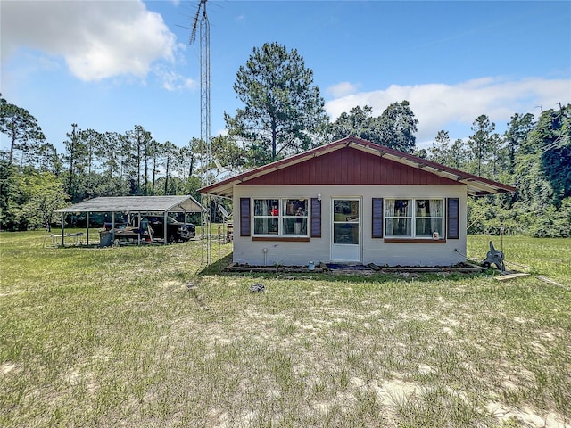 view of front of property featuring a front lawn and a carport