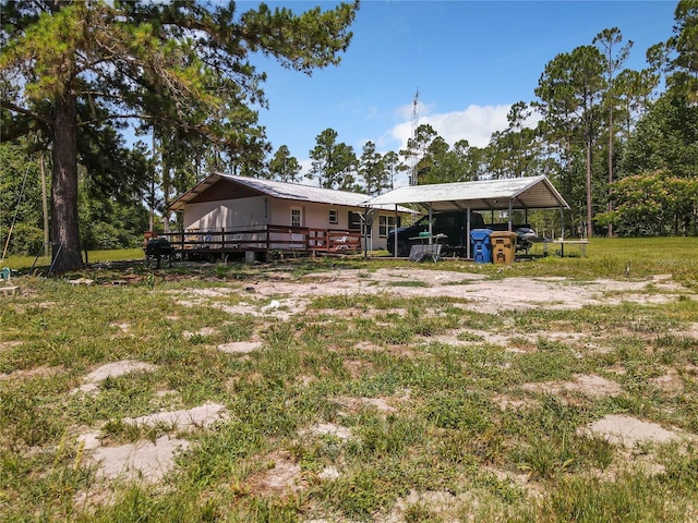 view of yard with a carport and a deck