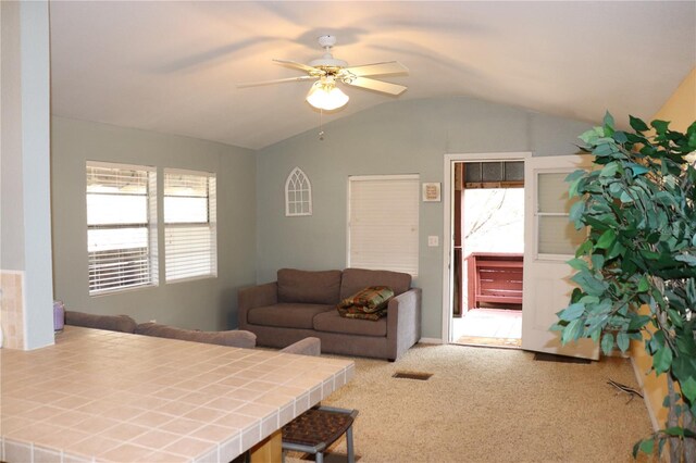 living room featuring ceiling fan, carpet floors, and lofted ceiling