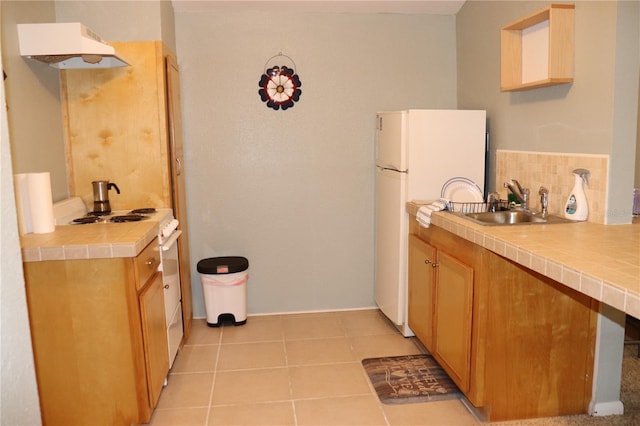 kitchen featuring tile countertops, white appliances, sink, light tile patterned floors, and tasteful backsplash