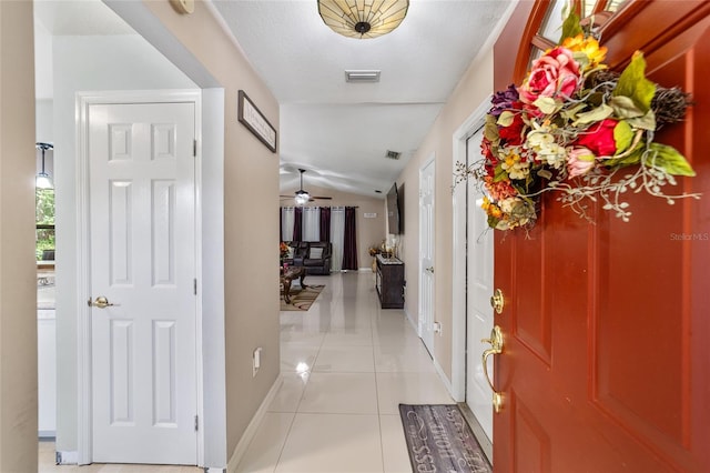 foyer with ceiling fan, light tile patterned floors, and lofted ceiling