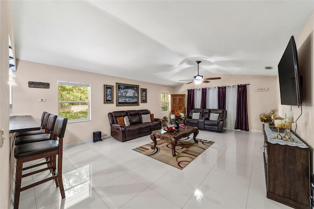 living room featuring ceiling fan, light tile patterned flooring, and lofted ceiling