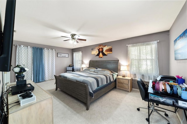 bedroom featuring multiple windows, light carpet, and ceiling fan