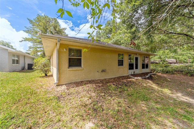 back of house featuring central AC unit and a yard