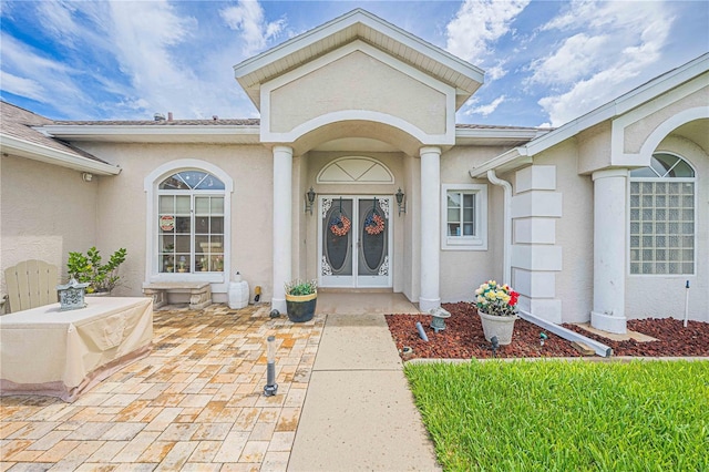 doorway to property featuring stucco siding