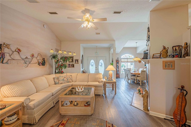 living room with french doors, a textured ceiling, vaulted ceiling, ceiling fan, and dark hardwood / wood-style floors