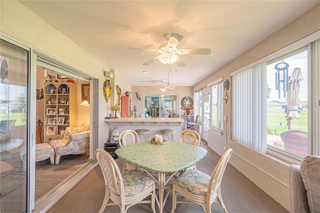 dining space with carpet, built in shelves, a textured ceiling, and ceiling fan